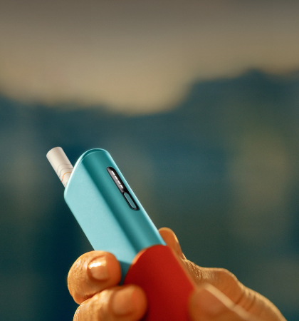 Man holding an IQOS ILUMA i ONE device, seen from left side